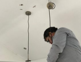 an electrician installing a chandelier